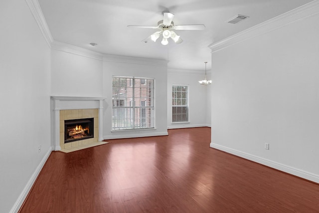 unfurnished living room featuring ornamental molding, dark hardwood / wood-style floors, ceiling fan with notable chandelier, and a fireplace