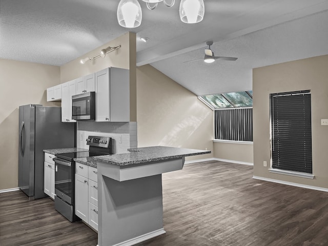 kitchen with white cabinetry, vaulted ceiling with beams, stainless steel appliances, and a kitchen breakfast bar