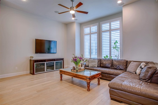 living room with light hardwood / wood-style flooring and ceiling fan