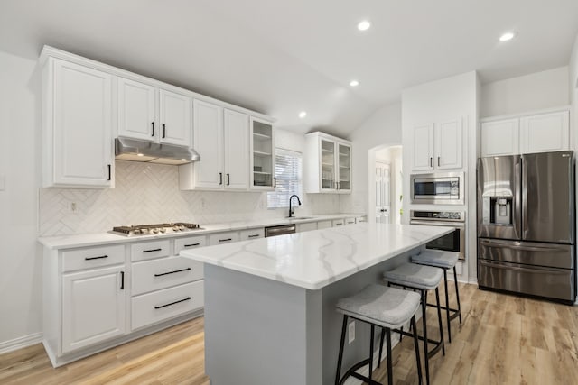 kitchen featuring stainless steel appliances, sink, a kitchen island, and white cabinets