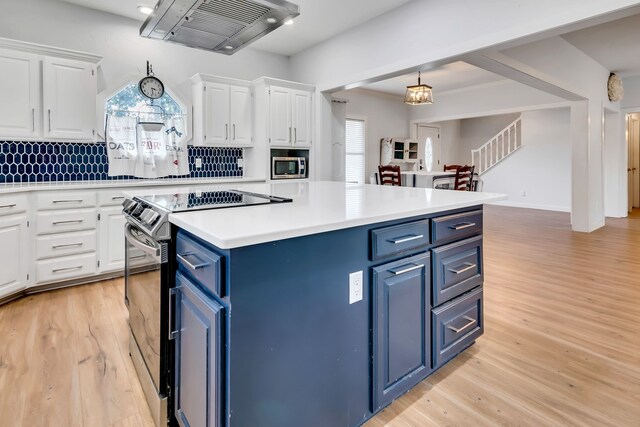 kitchen with white cabinetry, stainless steel appliances, a center island, and island exhaust hood