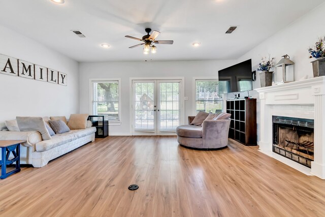 kitchen featuring pendant lighting, light hardwood / wood-style flooring, appliances with stainless steel finishes, island range hood, and white cabinets