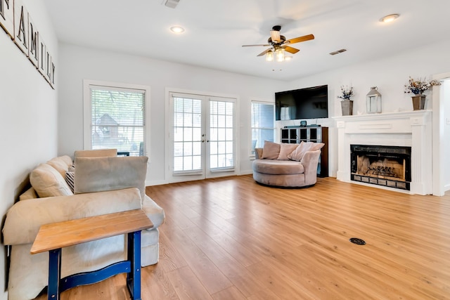 living room with hardwood / wood-style flooring, french doors, and ceiling fan