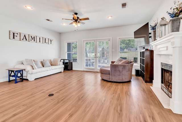 living room with french doors, ceiling fan, a healthy amount of sunlight, and light wood-type flooring