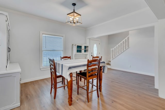 dining room featuring crown molding, light hardwood / wood-style floors, and a notable chandelier