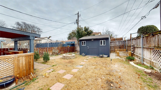 view of yard with a shed and an outdoor fire pit