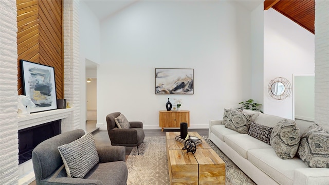 living room with a fireplace, high vaulted ceiling, and hardwood / wood-style floors