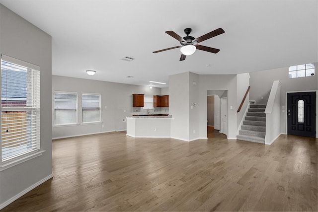 unfurnished living room with dark hardwood / wood-style floors and ceiling fan