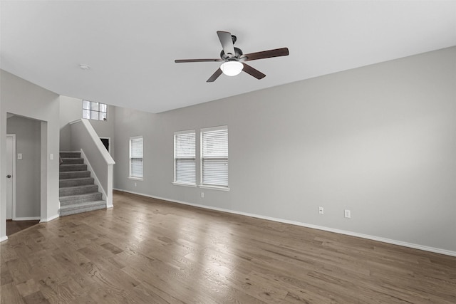 unfurnished living room with ceiling fan and dark hardwood / wood-style floors