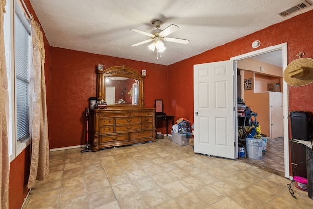 bedroom with ceiling fan and a textured ceiling