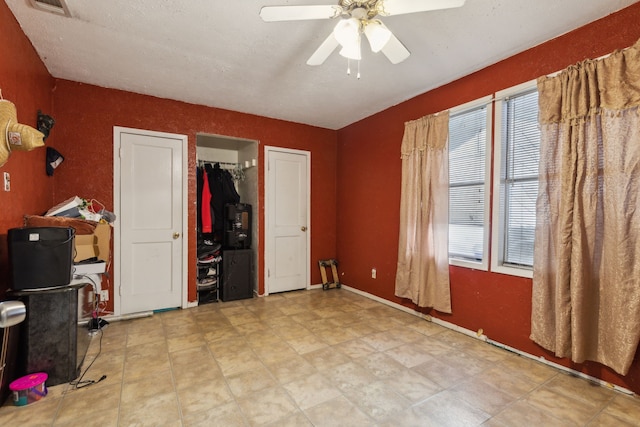 interior space with ceiling fan