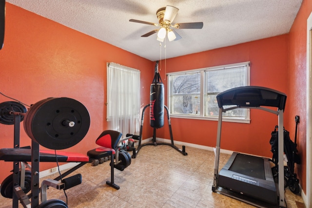 workout room with ceiling fan and a textured ceiling