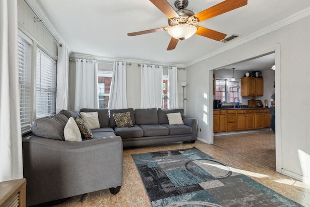 living room with sink, crown molding, and ceiling fan