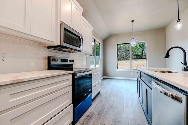 kitchen featuring pendant lighting, stainless steel appliances, sink, and white cabinets