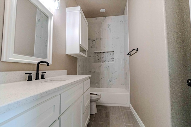 full bathroom with vanity, tiled shower / bath, and toilet