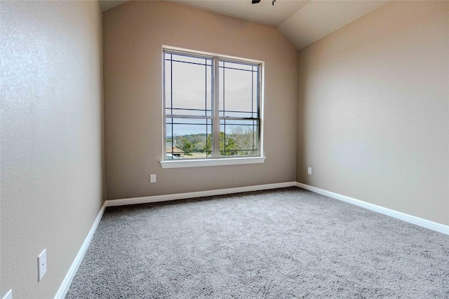 spare room featuring vaulted ceiling and carpet flooring