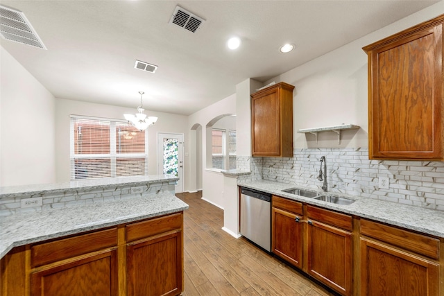 kitchen featuring sink, dishwasher, light stone countertops, decorative backsplash, and decorative light fixtures