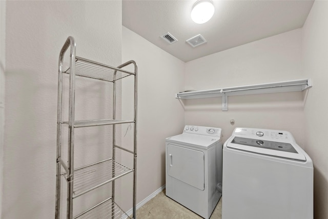 washroom with separate washer and dryer and light tile patterned floors