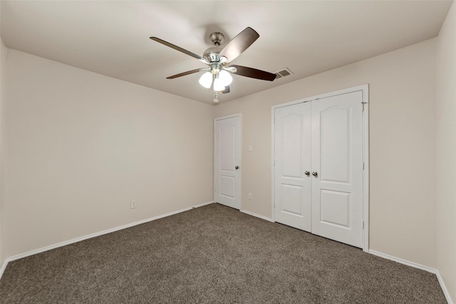 unfurnished bedroom featuring ceiling fan, dark carpet, and a closet