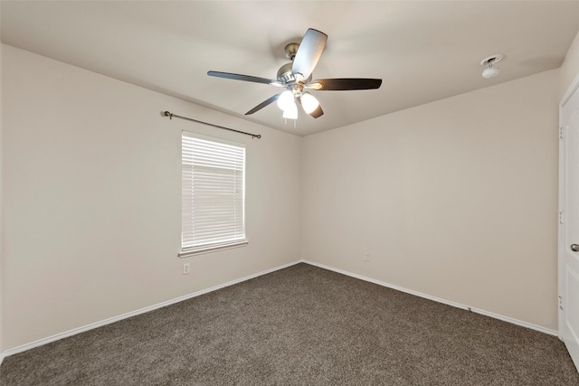 empty room with ceiling fan and dark carpet