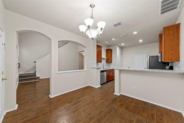 kitchen featuring appliances with stainless steel finishes, dark hardwood / wood-style floors, sink, and backsplash