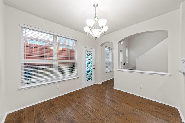 spare room with dark hardwood / wood-style flooring and a chandelier