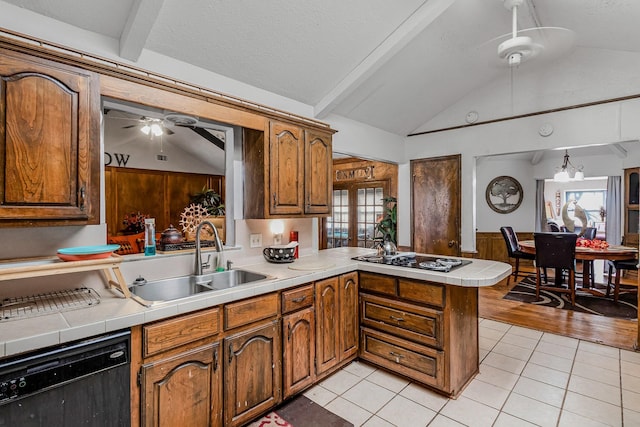 kitchen featuring sink, light tile patterned floors, lofted ceiling with beams, black appliances, and kitchen peninsula