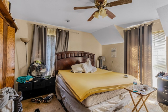 bedroom with ceiling fan, lofted ceiling, and carpet floors