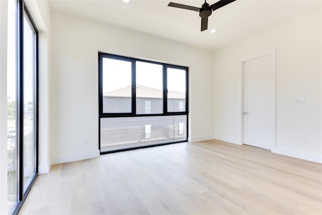 empty room with ceiling fan and light hardwood / wood-style flooring