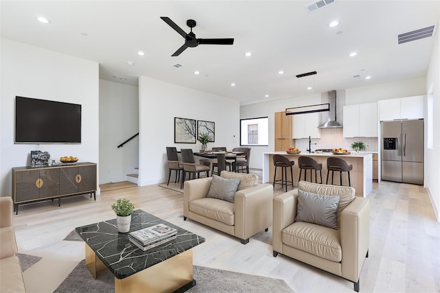 living room featuring ceiling fan and light wood-type flooring