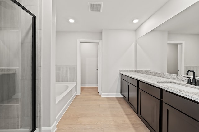 bathroom featuring vanity, wood-type flooring, and independent shower and bath