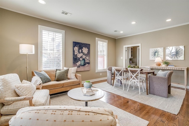 living room with recessed lighting, visible vents, ornamental molding, wood finished floors, and baseboards