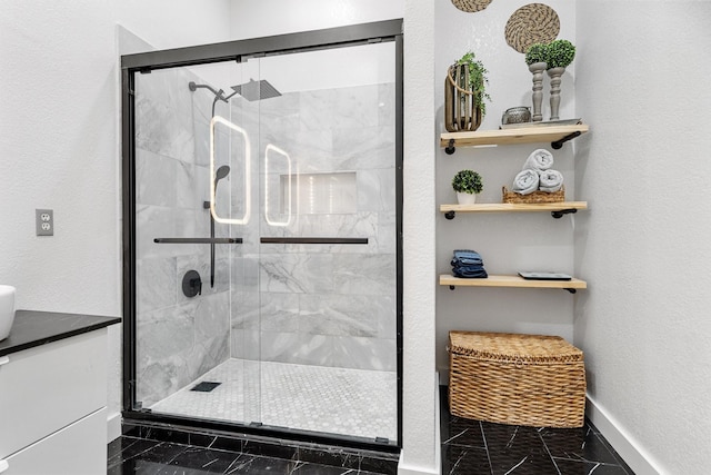 bathroom with marble finish floor, a stall shower, and baseboards