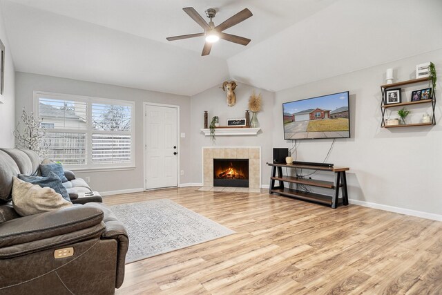 living room featuring ceiling fan, lofted ceiling, and light hardwood / wood-style flooring