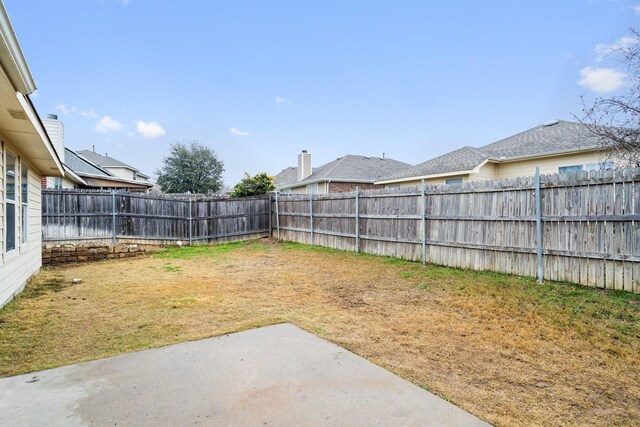 back of house featuring a patio area, a chimney, fence, and a lawn