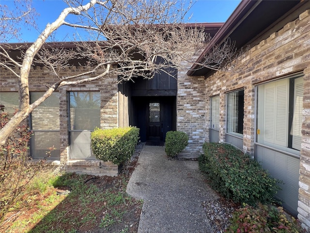 entrance to property featuring brick siding