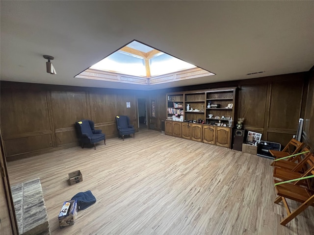 interior space with light wood-type flooring and a skylight