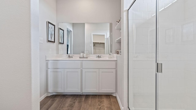 bathroom with wood-type flooring, an enclosed shower, and vanity