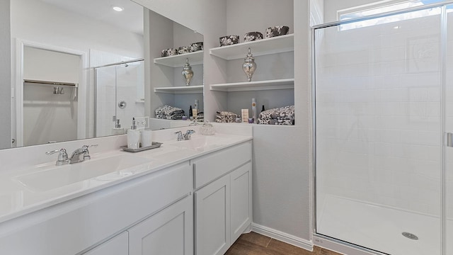 bathroom featuring an enclosed shower, vanity, and wood-type flooring