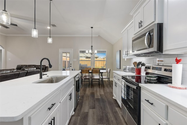 kitchen with sink, a kitchen island with sink, stainless steel appliances, white cabinets, and decorative light fixtures