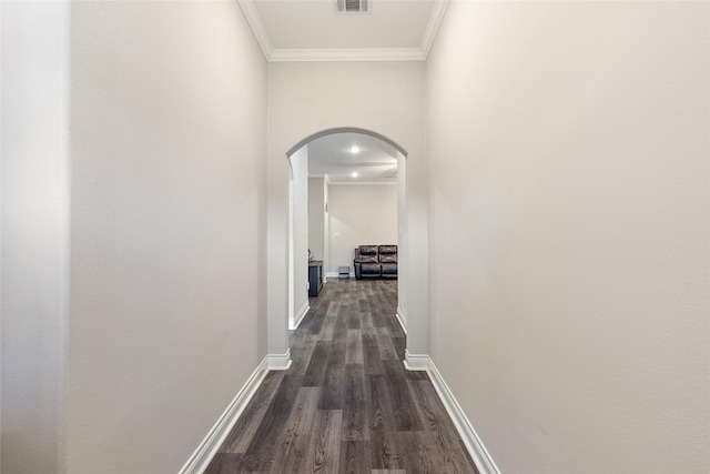 hall with ornamental molding and dark wood-type flooring