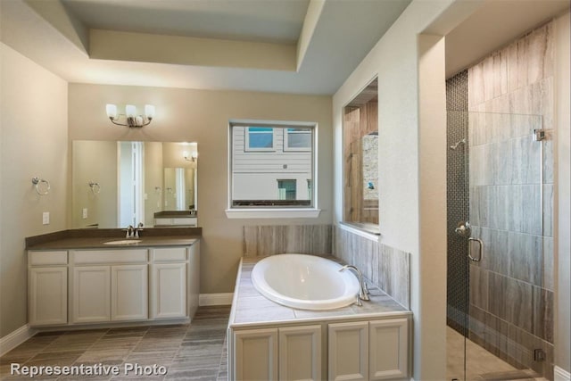 bathroom with separate shower and tub, tile patterned floors, vanity, and a raised ceiling