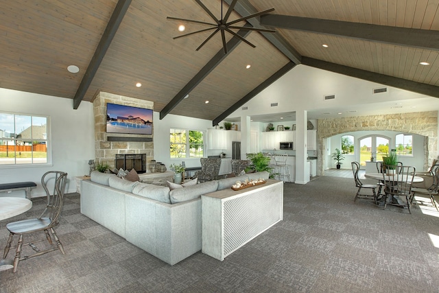 unfurnished living room featuring beamed ceiling, high vaulted ceiling, carpet flooring, and a fireplace