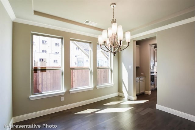 unfurnished dining area featuring dark wood-type flooring, ornamental molding, a chandelier, and a healthy amount of sunlight