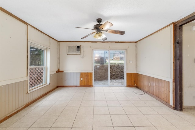 spare room with a wall mounted AC, crown molding, a wealth of natural light, and ceiling fan