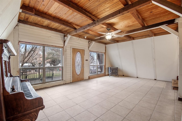 unfurnished sunroom featuring beam ceiling, a wealth of natural light, wooden ceiling, and a wood stove