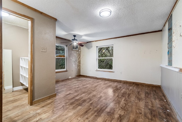 empty room with crown molding, a textured ceiling, ceiling fan, and light hardwood / wood-style flooring