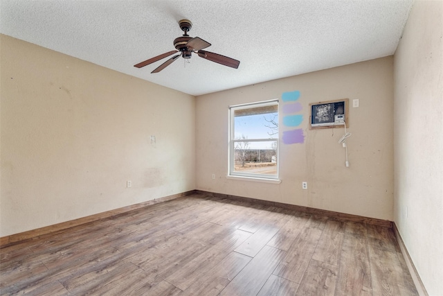 spare room featuring ceiling fan, light hardwood / wood-style flooring, and a textured ceiling