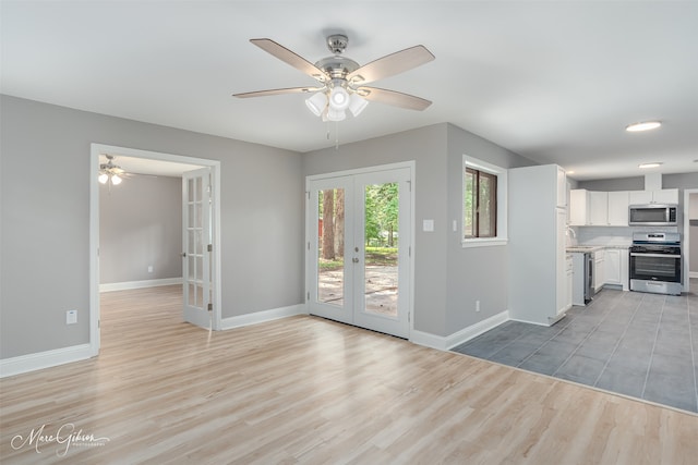 unfurnished living room featuring french doors, ceiling fan, sink, and light hardwood / wood-style flooring