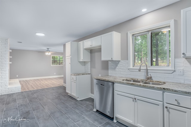 kitchen featuring white cabinetry, sink, stainless steel dishwasher, and backsplash